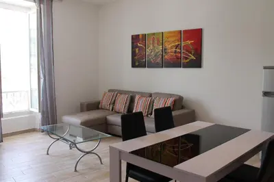a living room with a couch and a table at Les Appartements du Port in Bonifacio