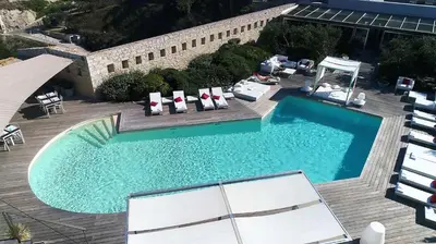 an overhead view of a swimming pool with chairs and a deck at Hotel Spa Genovese in Bonifacio