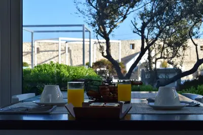 a table with two glasses of orange juice on it at Hotel Spa Genovese in Bonifacio