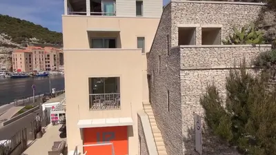 a building next to a body of water at Hotel Spa Genovese in Bonifacio