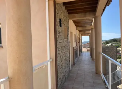 a corridor of a building with a balcony at Hôtel Lilium Maris in Sartène
