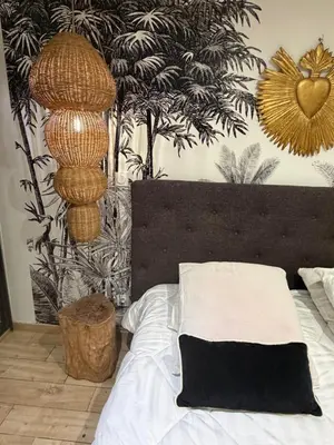 a bedroom with a bed and a wall with plants at Domaine Colonna-Santini Gîte avec Piscine & Spa, Vue Mer et Montagnes in Porri