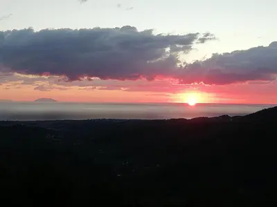 a sunset over the ocean with the sun in the sky at Domaine Colonna-Santini Gîte avec Piscine & Spa, Vue Mer et Montagnes in Porri