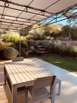 a picnic table and a bench under a canopy at Cantari in Calenzana