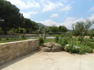 a garden with rocks and a stone wall at Cantari in Calenzana