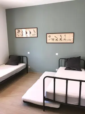 two beds in a room with white walls and wooden floors at Cantari in Calenzana