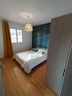 a bedroom with a bed in the corner of a room at les JARDINS de PRATAVONE in Aja dʼOnica
