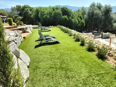 a row of benches sitting on a grass field at les JARDINS de PRATAVONE in Aja dʼOnica