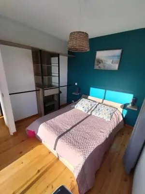 a bedroom with a bed with a blue wall at les JARDINS de PRATAVONE in Aja dʼOnica