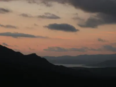 a sunset over the mountains and a body of water at Casa Di Minnana in Petreto-Bicchisano