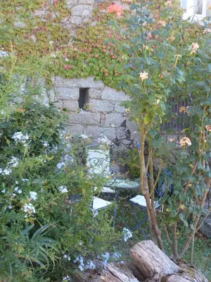 a stone building with a small window in a garden at Casa Di Minnana in Petreto-Bicchisano