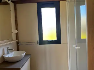 a bathroom with a sink and a window at Ri-Veu corse dans camping marina di sorbo in Sorbo-Ocagnano