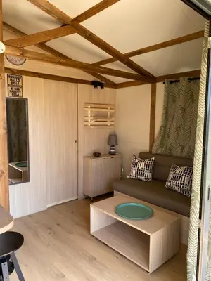 a living room with a couch and a table at Ri-Veu corse dans camping marina di sorbo in Sorbo-Ocagnano