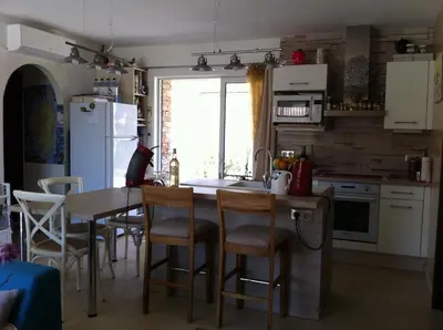 a kitchen with a sink and a table with chairs at L'Hacienda Piscine chauffée à 28, spa, boulodrome et court de Tennis privés, 2 villas indépendantes in Porto-Vecchio