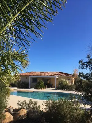 a swimming pool in front of a house at L'Hacienda Piscine chauffée à 28, spa, boulodrome et court de Tennis privés, 2 villas indépendantes in Porto-Vecchio