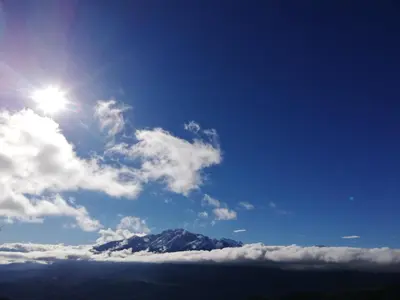 a mountain in the sky with the sun and clouds at Parfumu Di Celu in Corte