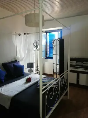 a bedroom with a canopy bed and a window at Parfumu Di Celu in Corte