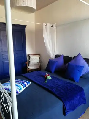 a bedroom with a bed with blue sheets and blue pillows at Parfumu Di Celu in Corte