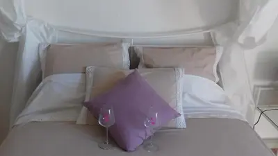 a white bed with two wine glasses on it at Parfumu Di Celu in Corte