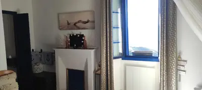 a mirror in a room with a fireplace and a window at Parfumu Di Celu in Corte