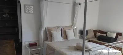 a white bedroom with a bed and a couch at Parfumu Di Celu in Corte