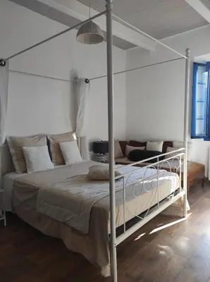 a bedroom with a bed with a metal canopy at Parfumu Di Celu in Corte
