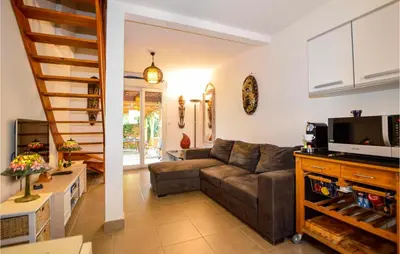 a living room with a couch and a television at 3 Bedroom Gorgeous Home In Cervione in Cervione