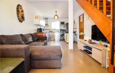 a living room with a couch and a kitchen at 3 Bedroom Gorgeous Home In Cervione in Cervione