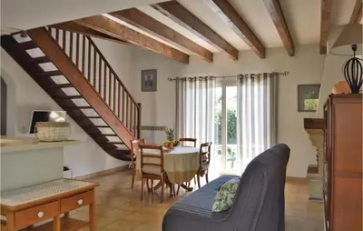 a living room with a table and a dining room at 3 Bedroom Lovely Home In Cervione in Cervione