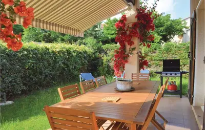 a wooden table and chairs on a patio at 3 Bedroom Lovely Home In Cervione in Cervione