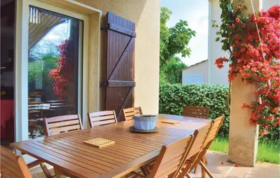 a wooden table and chairs on a patio at 3 Bedroom Lovely Home In Cervione in Cervione
