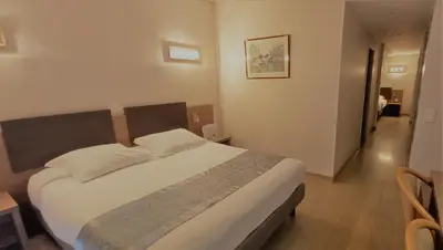 a bedroom with a large bed in a room at Hotel Poretta in Lucciana