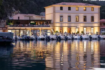 a large building next to a body of water at Hotel Centre Nautique in Bonifacio