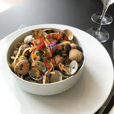 a bowl of clams and mussels on a white plate at Hotel Centre Nautique in Bonifacio