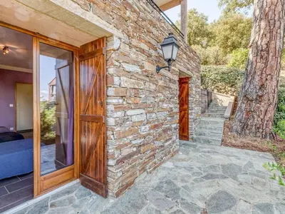 a stone building with a door and a tree at Holiday Home A Mandria by Interhome in Ghisoni