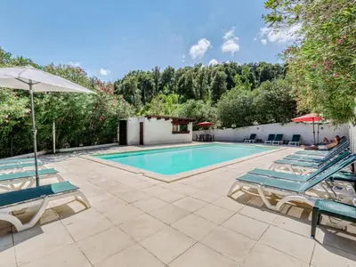 a swimming pool with lounge chairs and an umbrella at Holiday Home A Mandria by Interhome in Ghisoni