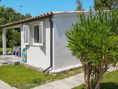 a small white house with a window and a tree at Holiday Home A Suara-1 by Interhome in Ghisonaccia
