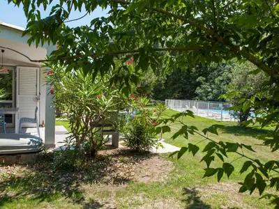 a yard with a bench and a tree at Holiday Home A Suara-1 by Interhome in Ghisonaccia