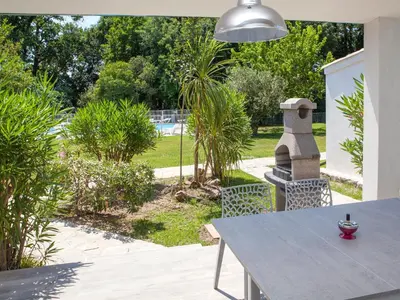 a patio with a table and chairs and a garden at Holiday Home A Suara-1 by Interhome in Ghisonaccia