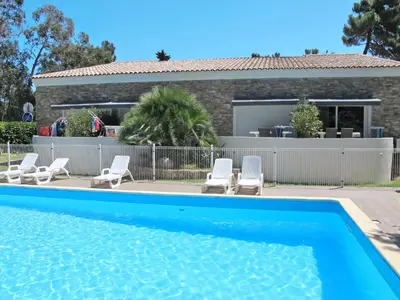 a swimming pool with chairs and a house at Apartment A Suara di Mare by Interhome in Ghisonaccia