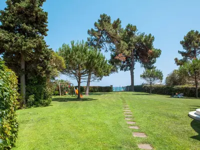 a grassy field with trees and a playground at Apartment A Suara di Mare by Interhome in Ghisonaccia