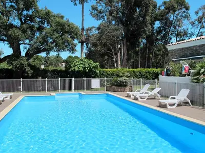 a swimming pool with two lounge chairs and a pool at Apartment A Suara di Mare by Interhome in Ghisonaccia