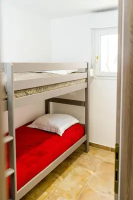 a bedroom with two bunk beds with a red blanket at Apartment A Suara di Mare by Interhome in Ghisonaccia