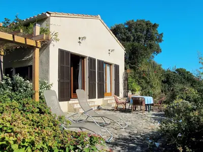 a house with a table and chairs in front of it at Holiday Home Svyntha by Interhome in Prunelli-di-Fiumorbo