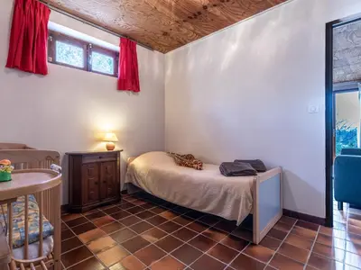 a bedroom with a bed and a table and a window at Holiday Home Svyntha by Interhome in Prunelli-di-Fiumorbo