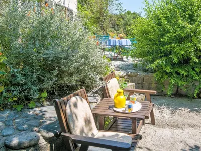 a wooden table with chairs and a yellow pitcher on it at Holiday Home Svyntha by Interhome in Prunelli-di-Fiumorbo