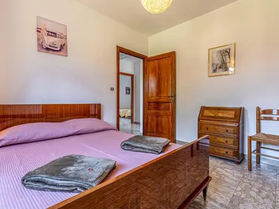 a bedroom with a bed with purple sheets and a dresser at Apartment Casa Antoinette by Interhome in Prunelli-di-Fiumorbo