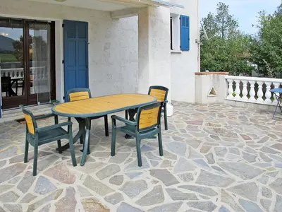 a wooden table and chairs on a patio at Apartment Casa Antoinette by Interhome in Prunelli-di-Fiumorbo