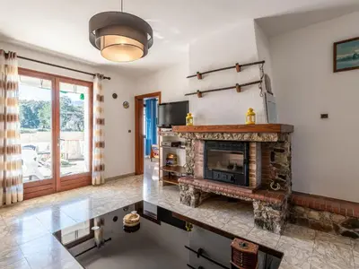 a large living room with a stone fireplace at Apartment Casa Antoinette by Interhome in Prunelli-di-Fiumorbo