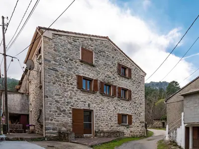 an old stone house with windows on a street at Holiday Home Migone de Sampolo by Interhome in Ghisoni